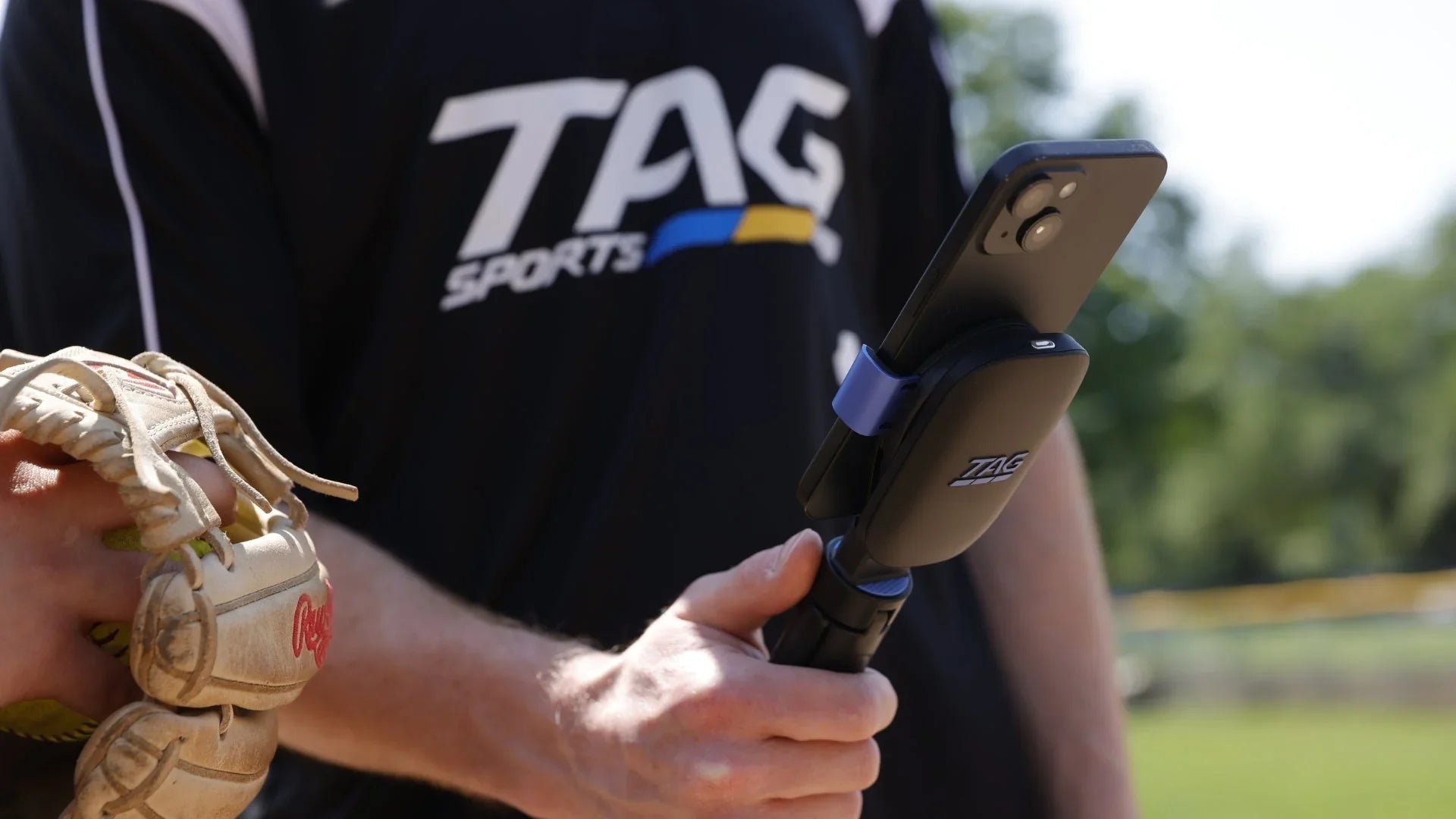 Two athletes view phone screen to review pitching data from a recent practice.