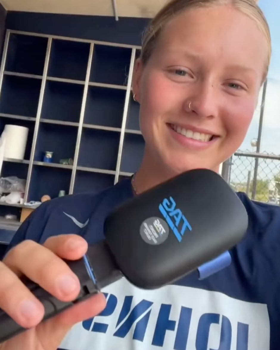 Person holding a radar device with a visible brand logo, standing in an indoor setting.