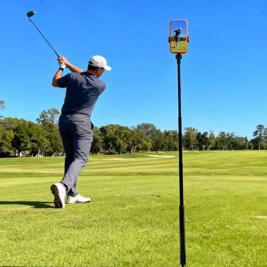 Golfer swinging a club with phone placed atop tripod.