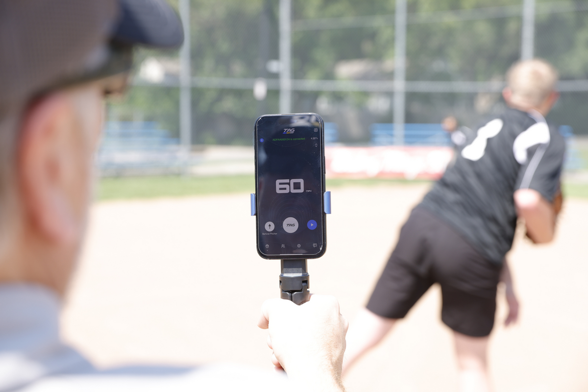 Baseball player pitching a baseball while having speed tracked.