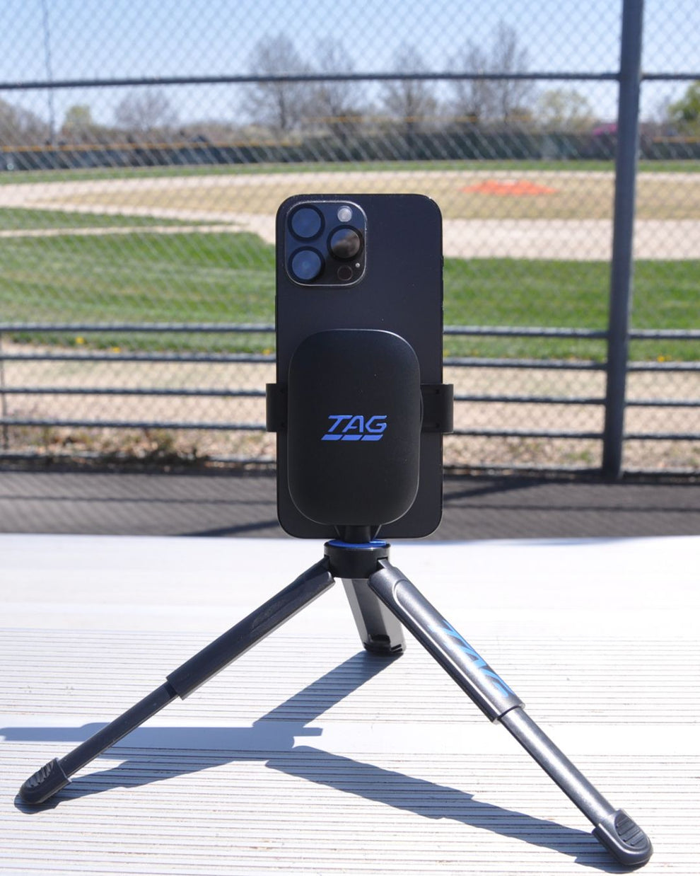 Phone holder with a tripod on a sports field